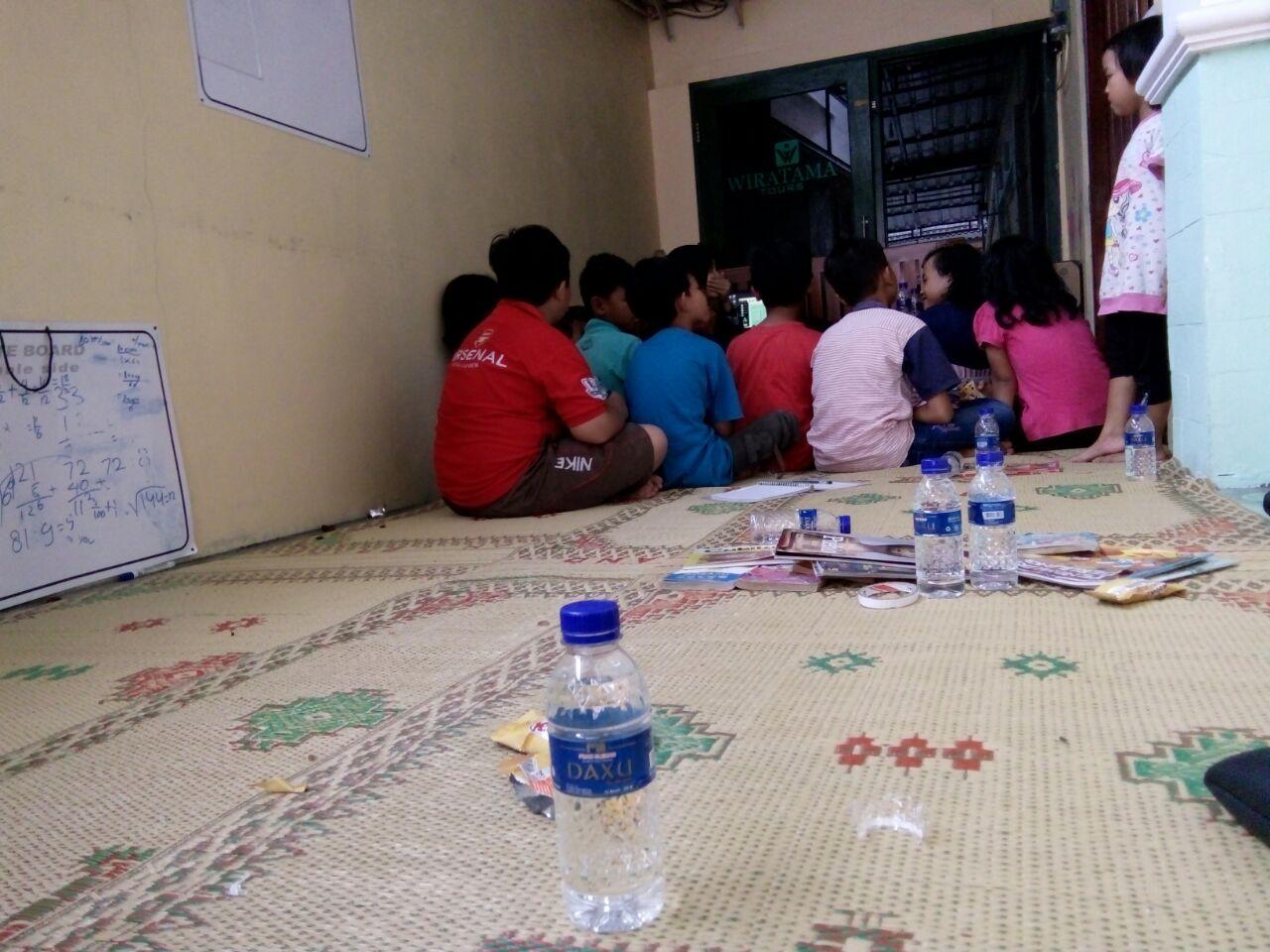 Anak-anak duduk berkumpul di tikar