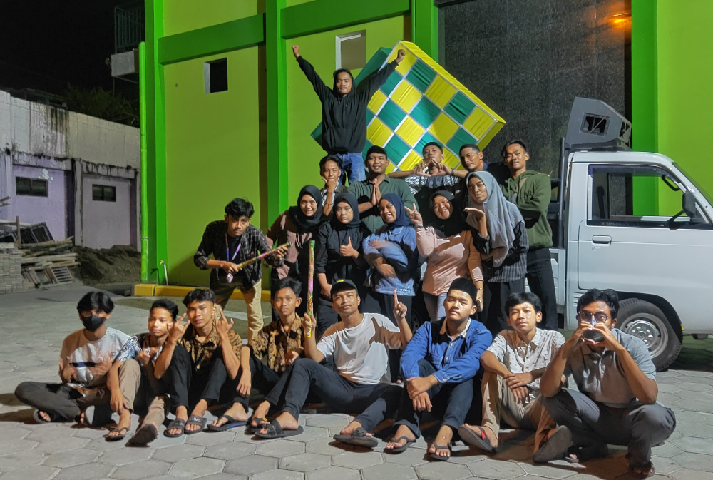 kumpulan pemuda berfoto di depan masjid berdinding hijau